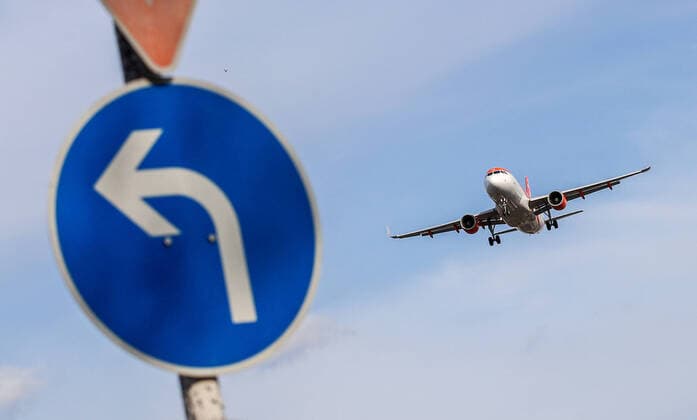 Flugverkehr waehrend Coronakrise Berlin, 16.03.20, Blick auf EasyJet Maschine im Anflug auf Flughafen Berlin Tegel. Im Vordergrund blaues Schild mit Linksabbieger Pfeil. Aufgrund des Coronavirus streichen die Airlines grosse Teile ihrer Fluege. Berlin Berlin Deutschland Flughafen Tegel