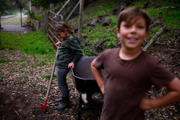 Child with shovel looking down at the ground with boy in foreground Santa Cruz, CA, United States ,model released, Symbolfoto CR_LICE200214-310449-01