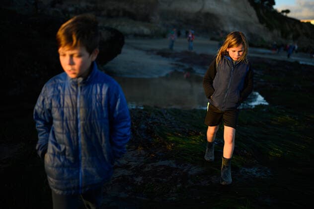 IMAGO Creative: UN Welt-Habitat-Tag am 3. Oktober Two children looking down and walking on seagrass at sunset low tide Santa Cruz, CA, United States ,model released, Symbolfoto CR_LICE200214-310469-01