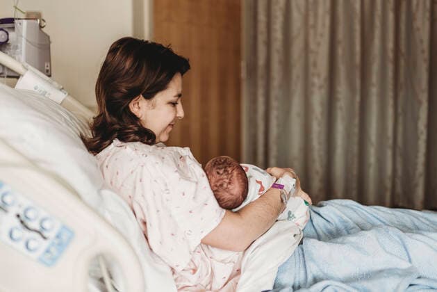 IMAGO Creative: Lokalhelden - Gesundheits- und Rettungskräfte Side view of happy mother holding newborn son in hospital San Diego, CA, United States ,model released, Symbolfoto CR_KESM200220-261012-01