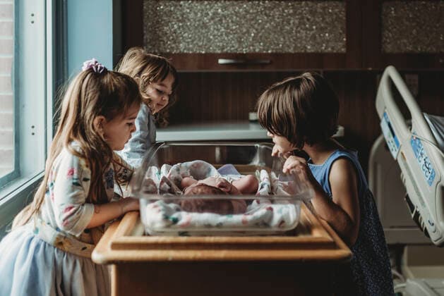 IMAGO Creative: Lokalhelden - Gesundheits- und Rettungskräfte Siblings looking at newborn brother in hospital bassinet San Diego, CA, United States ,model released, Symbolfoto CR_KESM200220-261104-01