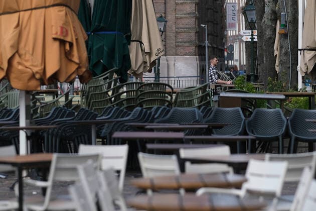 A man puts away empty chairs at Het Plein, a square located adjacent to the Binnenhof, as bars and restaurants are closed due to the Coronavirus (Covid-19) pandemic on March 16, 2020 in The Hague, Netherlands.  (124471045)