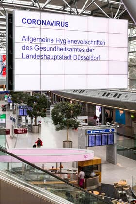 Flughafen Düsseldorf aufgrund der Corona-Krise ungewohnt leer, große Displays mit allgemeinen Hygienevorschriften zu Vorbeugung