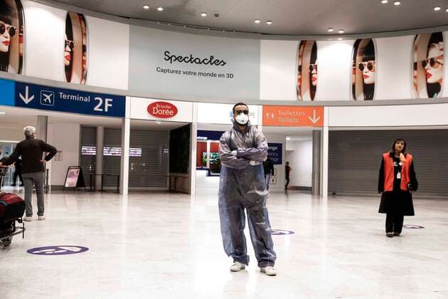 Paris, France, March 19, 2020 - Atmosphere at Paris Charles de Gaulle Airport after the head of state ordered people to stay home to stop the spread of Covid-19 - A man in a full-body suit with mask and glove is waiting in the arrivals hall.  Copyright: xAlexisxSciardx