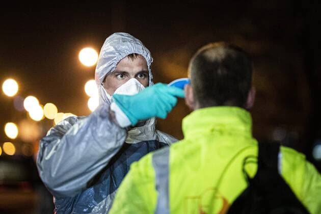 Ein Mann im Schutzanzug kontrolliert die Koerpertemperatur von Einreisenden an der deutsch-polnischen Grenze in Goerlitz, 19.03.2020. In der Nacht vom 14.03. zum 15.03. wurden die Grenzen zwischen Deutschland und Polen sowie Tschechien geschlossen, um die Ausbreitung des Coronaviruses einzudaemmen. Goerlitz Deutschland