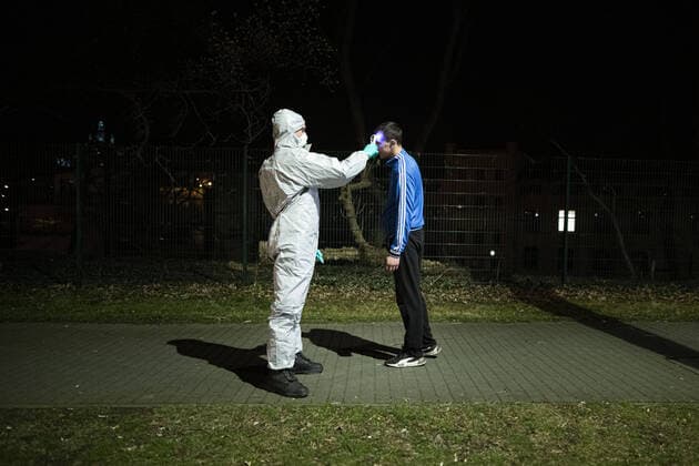 Ein Mann im Schutzanzug kontrolliert die Koerpertemperatur von Einreisenden an der deutsch-polnischen Grenze in Goerlitz, 19.03.2020. In der Nacht vom 14.03. zum 15.03. wurden die Grenzen zwischen Deutschland und Polen sowie Tschechien geschlossen, um die Ausbreitung des Coronaviruses einzudaemmen. Goerlitz Deutschland