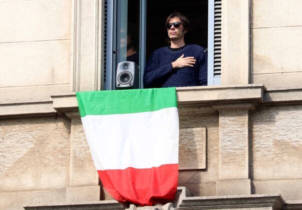 foto ipp giorgio rossi milano 20 03 2020 emergenza coronavirus - radio per l italia: tutte le emittenti nazionali hanno suonato in contemporanea l inno nazionale nella foto un ragazzo canta l inno affacciata alla finestra di casa con una bandiera dell italia  0