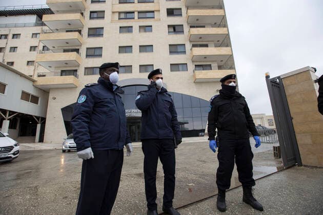 March 20, 2020, Bethlehem, West Bank: Palestinian policemen in front of Paradise Hotel during the release of quaranined employees inside. Bethlehem West Bank - ZUMAb133 20200320_zap_b133_027 Copyright: xMustafaxBaderx