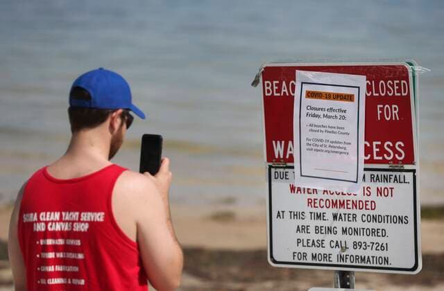 March 20, 2020, St. Petersburg, Florida, USA: Zac Giparas, 28, takes a picture of the Covid-19 update beach closure sign along the sand at North Shore Park on Friday, March 20, 2020 in St. Petersburg. Giparas is a USF grad student currently on spring break. It s a safety concern. You gotta do what you can for public safety, Giparas said regarding the order for the beaches to close. Especially if people aren t taking it seriously enough. Pinellas County has announced that all public beaches will close tonight at 11:59 p.m. St. Petersburg USA - ZUMAs70_ 20200320_zan_s70_032 Copyright: xDirkxShaddx