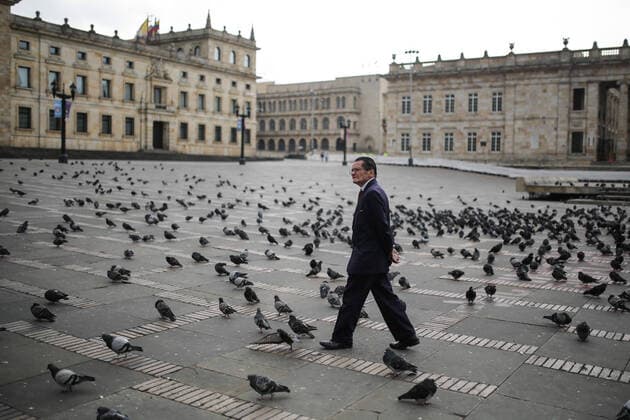 (200321) -- BOGOTA, March 21, 2020 (Xinhua) -- A man walks on the Bolivar Square in Bogota, Colombia, March 20, 2020. The Colombian capital of Bogota began on Friday the mandatory isolation drill decreed by mayor Claudia Lopez in order to prepare for a quarantine aimed at containing the COVID-19 pandemic. The mandatory isolation drill in the Colombian capital, home to more than seven million people and where 56 of Colombia s 145 cases of COVID-19 have been confirmed, will remain in effect until midnight on March 23. (Photo by Jhon Paz Xinhua) COLOMBIA-BOGOTA-MANDATORY ISOLATION 