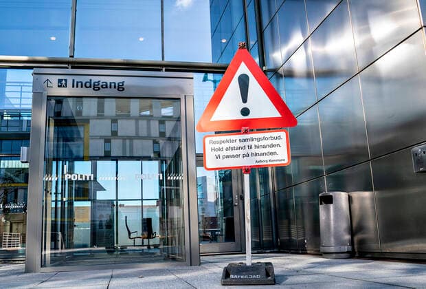 Nyt advarselsskilt om forbud mod stoerre forsamling foer borgmester Thomas Kastrup-Larsen og politidirektoer ved Nordjyllands Politi Anne Marie Roum Svendsen informerer om coronasituationen og tiltag i forbindelse med haandhaevelse af forsamlingsforbuddet paa et pressemoede paa politigaarden i Aalborg, loerdag den 21. marts 2020.. Paa grund af COVID-19 er befolkningen blevet bedt om saa vidt muligt at holde sig indendoers.. , Aalborg Jylland Denmark Copyright: HenningxBagger HenningxBaggerx COP105 spdk20200321-103632-L