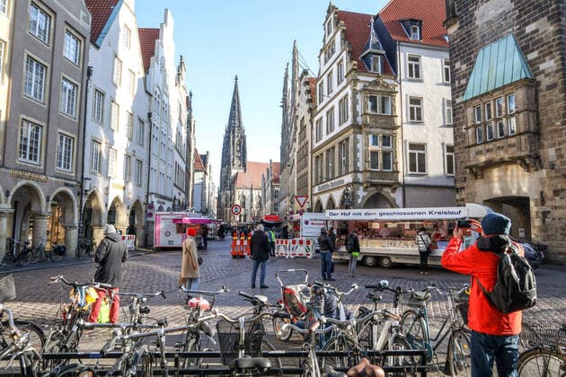 DEU, Deutschland, Nordrhein-Westfalen, Münster, 21.03.2020: Anfang des 20. Jahrhunderts war der Wochenmarkt Münster vom Prinzipalmarkt auf den Domplatz umgezogen. Wegen der Corona Ansteckungsgefahr wurde der Wochenmarkt entzerrt, damit zwischen Ständen Freiflächen für wartende Kunden entstehen. Einige Marktstände stehen deshalb am Prinzipalmarkt und am Michaelisplatz werden Stände aufgebaut. Abstandsregeln wurden von den Kunden beachtet.