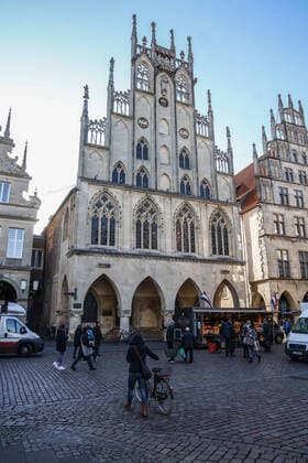 DEU, Deutschland, Nordrhein-Westfalen, Münster, 21.03.2020: Anfang des 20. Jahrhunderts war der Wochenmarkt Münster vom Prinzipalmarkt auf den Domplatz umgezogen. Wegen der Corona Ansteckungsgefahr wurde der Wochenmarkt entzerrt, damit zwischen Ständen Freiflächen für wartende Kunden entstehen. Einige Marktstände stehen deshalb am Prinzipalmarkt und am Michaelisplatz werden Stände aufgebaut. Abstandsregeln wurden von den Kunden beachtet.