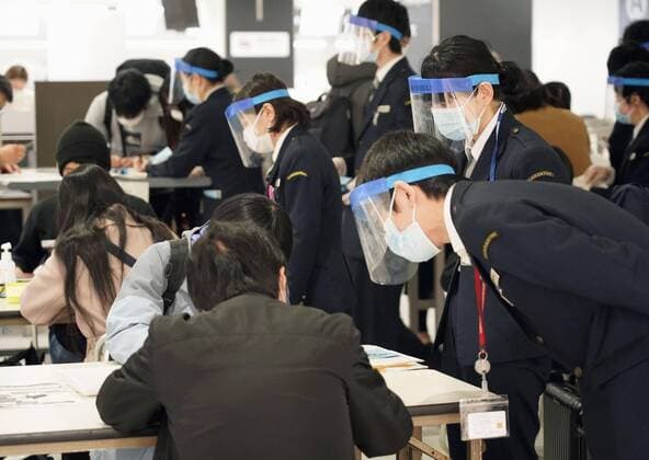 Two-week quarantine in Japan for travelers from Europe Arriving passengers (in seats) fill out forms as quarantine officials watch at Narita airport near Tokyo on March 21, 2020. Travelers from Europe, Egypt and Iran are required to self-quarantine for 14 days after their arrival as Japan attempts to contain the spread of the new coronavirus. 