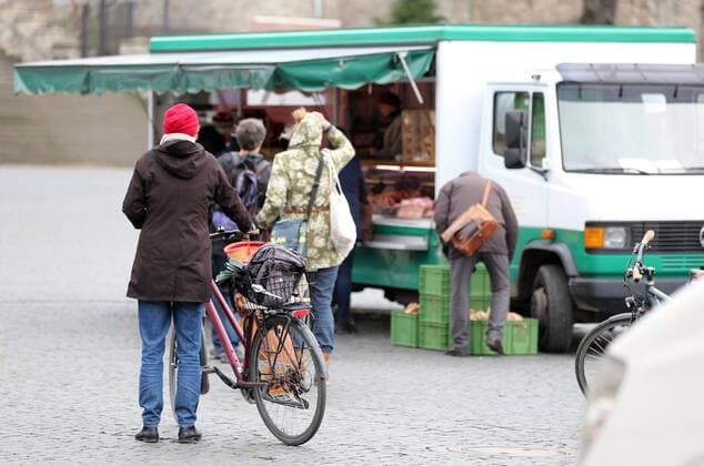 Corona 21.03.2020 , Erfurt, Markt am Domplatz, es sind weniger Menschen als sonst unterwegs, sie halten den vorgegebenen Mindestabstand von 1,5 Metern ein, dieser dient dem Schutz vor Ansteckung durch das Corona-Virus, Händler verweisen mit Schildern auf den Abstand