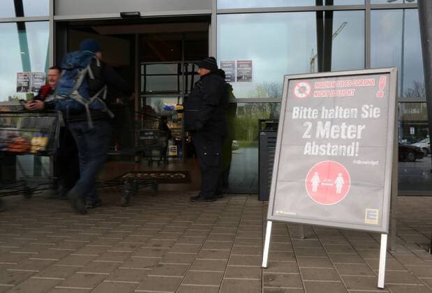 Corona 21.03.2020 , Erfurt, EDEKA-Markt, ein Schild am Eingang mit dem Hinweis - Bitte halten Sie 2 Meter Abstand - eine Person mit Einkaufswagen betritt den Markt, am Eingang steht Security