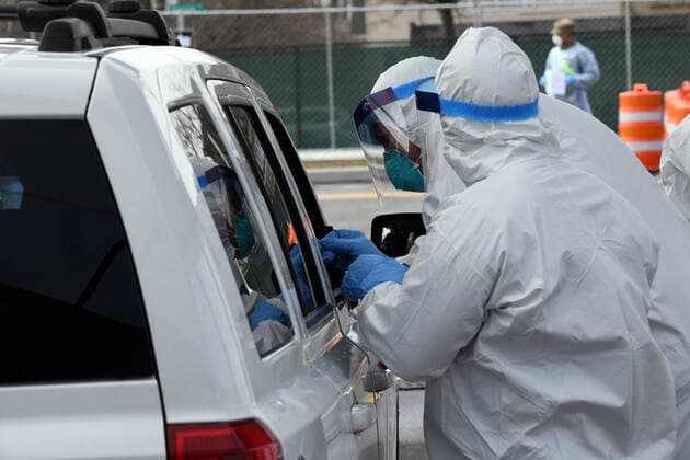 New York National Guard members collect samples from drivers at the drive-through COVID-19 Mobile Testing Center located at the South Beach Behavioral Center, Staten Island, New York, on March 19, 2020. Members of the New York Army and Air National Guard with the proper medical training and experience are supporting local medical professionals by collecting samples for possible infection of the COVID-19 virus.  WAX2020032102 PATRICKxCORDOVA