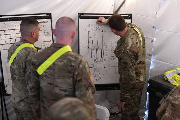 CPT Miles Kirwin, Commander of Alpha Company, 1st Battalion, 69th Infantry, New York Army National Guard, briefs team members on troop support locations before the opening of the drive-through COVID-19 Mobile Testing Center located at the South Beach Behavioral Center, Staten Island, New York on March 19, 2020. Members of the New York Army and Air National Guard have been activated under Operation COVID-19 to support state and local response efforts.  WAX2020032105 PATRICKxCORDOVA