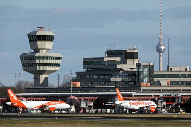 21.03.2020, Berlin, GER - Auswirkungen des Coronavirus: Flugzeuge in Parkposition am Flughafen Tegel. (abgestellt, Alltag, Ausgangsbeschraenkung, Ausgangssperre, aussen, Aussenaufnahme, Berlin, Coronaepidemie, Coronainfektion, Coronapandemie, Coronavirus, Coronavirus SARS-CoV-2, Covid 19, Covid-19, deutsch, Deutschland, easyjet, Europa, europaeisch, Flughafen, Flughafen Tegel, Flugverbot, Flugzeuge, Fruehjahr, Fruehling, Gebaeude, Gesellschaft, Jahreszeit, Kofferwagen, leer, Leere, menschenleer, parken, Parkposition, parkt, QF, Querformat, Reiseverbot, Reisewarnung, Shutdown, Stadt, Stadtansicht, Stadtbild, Stadtleben, Stillstand, Terminal, Tower, Westeuropa) 200321D004BERLIN.JPG