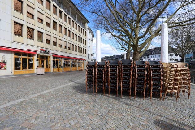 Coronavirus Angst, Auswirkungen wegen des Coronavirus (Covid-19), kommt noch eine Ausgangssperre in NRW? die Innenstadt von Siegen fast leer gefegt, gestapelte Stuehle beim Cafe Extrablatt Innenstadt am 21.03.2020 in Siegen Deutschland.