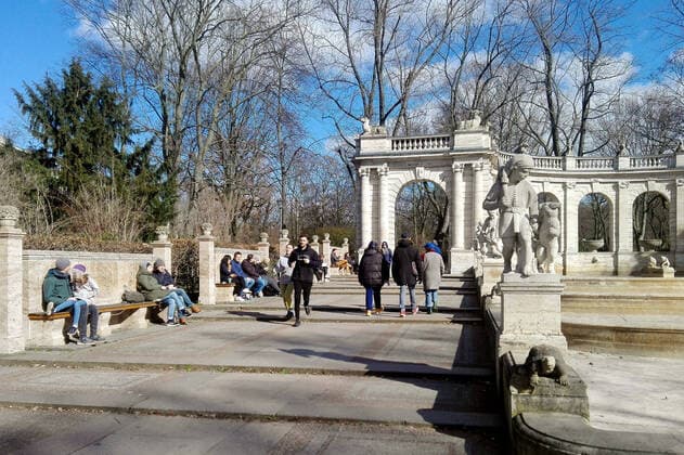 21.03.2020, Berlin - Deutschland. Menschen genießen einen Platz in der Sonne bei strahlendem Wetter und sitzen auf Bänken am Märchenbrunnen trotz Corona-Krise.