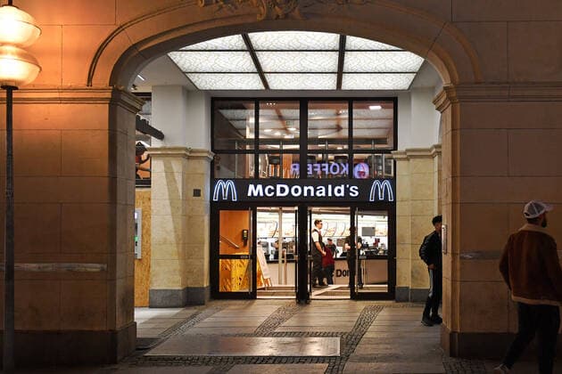 Themenbild Corona Pandemie:Bayern beschliesst Ausgangsbeschraenkung. Blick auf eine McDonalds Filiale am Stachus in Muenchen am spaeten Abend vor Verhaengung der Ausgangsbeschraenkung am 20.03.2020. Personal steht untaetig am offenen Eingang.
