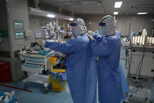 News Bilder des Tages (200321) -- WUHAN, March 21, 2020 -- Surgeon Zhang Xichun (L) from Inner Mongolia medical team wears a protective suit to conduct a surgery on a patient of COVID-19 in critical condition at a hospital in Wuhan, central China s Hubei Province, March 21, 2020. Doctors from Beijing, Jiangsu and other four different provinces have successfully completed the three-hour surgery on a male patient of COVID-19 in critical condition with joint efforts. (Photo by Xinhua) CHINA-HUBEI-WUHAN-COVID-19-SURGERY (CN) KexHao 