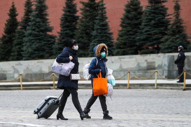 MOSCOW, RUSSIA - MARCH 21, 2020: Visitors in face masks with luggage walk in Red Square. As of 21 March 2020, Russia has confirmed more than 250 cases of the novel coronavirus, with more than 130 cases in Moscow. Sergei Savostyanov TASS  TS0D300F