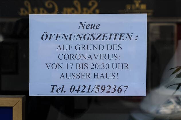 Zur Eindämmung des Coronavirus wurden Geschäftsschließungen angeordnet und werden Ausgangssperren diskutiert, das Foto zeigt ein Hinweisschild, Aushang im Fenster eines Geschäftes, Aufschrift: Neue Öffnungszeiten, Auf Grund des Coronavirus von 17 bis 20:30 Uhr ausser Haus, 21.03.2020, Bremen (Deutschland), News, Feature, Coronavirus Bremen