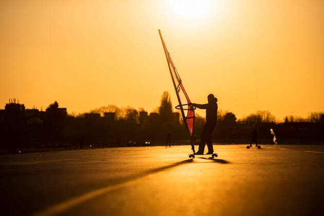 Menschen praktizieren Kitelandboarding in der Sonne am Tempelhofer Feld in Berlin am 21. Maerz 2020. Die Folgen des Coronavirus (COVID-19) lassen sich auch in der Stadt vermehrt spueren nachdem der Senat die Schliessung von Kultur und Sportveranstaltung, versammlungen von mehr als 50 Personen und den Respekt von Distanzen in den offen gebliebenen Betrieben und Gaststaetten. Viele Menschen profitieren trotzdem unbekuemmert vom gutem Wetter um Sport zu treiben oder Freunde am Parlk zu treffen. Auch aus diesem Grund wird vermehrt ueber weitere Einscharenkungen fuer Versammlungen und Zusammenkuenfte in oeffentliche Parks und Plaetze oder ueber eine Ausgangssperre diskutiert. Oeffentliches Leber weiter in Berlin wegen Coronavirus eingeschraenkt