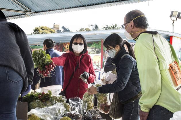 Masked shoppers select produce at Farmers Market on Alemany Street in San Francisco on Saturday, March 21, 2020. All of California is ordered to shelter in place.  SXP2020032103 TERRYxSCHMITT