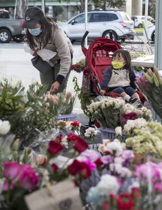 A woman shops for flowers at Farmers Market on Alemany Street in San Francisco on Saturday, March 21, 2020. All of California is ordered to shelter in place.  SXP2020032102 TERRYxSCHMITT