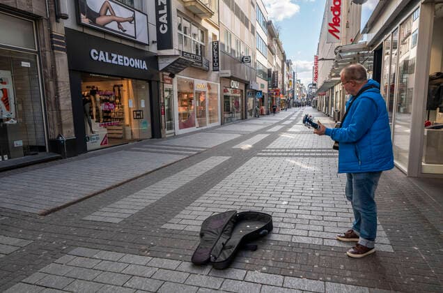 Auswirkungen der Coronavirus Krise, leere Einkaufsstrasse, einsamer Strassenmusiker, gegen 1400 Uhr am Samstag, normalerweise gehen hier tausende Menschen um diese Zeit einkaufen, Hohe Strasse in Köln, Deutschland, Corona Krise