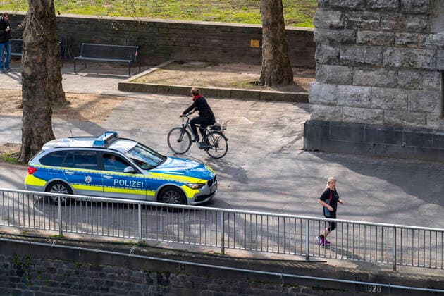 Auswirkungen der Coronavirus Krise, leere Einkaufsstrasse, Streifenwagen der Polizei, Rheinufer Heinrich-Böll-Platz, in Köln, Deutschland, Corona Krise