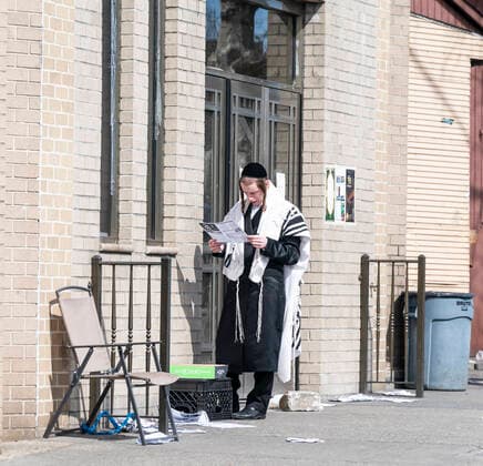 Williamsburg neighborhood reaction to COVID-19 Hasidic Satmar Jewish man reads local flyer in front of closed synagogue because of Coronavirus outbreak in Williamsburg neighborhood of Brooklyn New York New York United States Copyright: LevxRadin