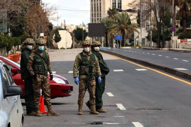 (200322) -- AMMAN, March 22, 2020 -- Soldiers of Jordanian army stand guard at a checkpoint after the start of the nationwide curfew in Amman, Jordan, March 21, 2020. On March 21, Jordan started imposing a curfew as part of the measures to limit the spread of coronavirus. (Photo by Muhammad Abu Ghosh Xinhua) JORDAN-AMMAN-COVID-19-CURFEW MohammadxAbuxGhosh 