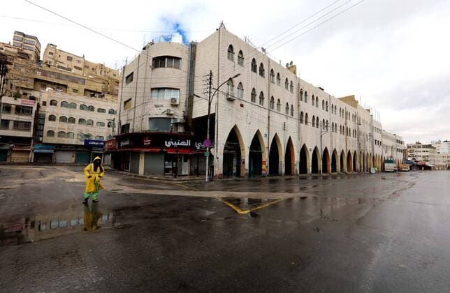 (200322) -- AMMAN, March 22, 2020 -- A cleaner sterilizes street in downtown Amman, Jordan, March 21, 2020. On March 21, Jordan started imposing a curfew as part of the measures to limit the spread of coronavirus. (Photo by Muhammad Abu Ghosh Xinhua) JORDAN-AMMAN-COVID-19-CURFEW MohammadxAbuxGhosh 