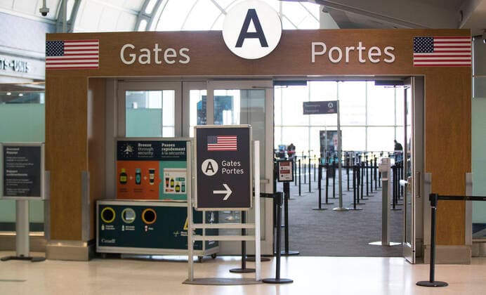 (200322) -- ONTARIO, March 22, 2020 -- The security gates to the U.S. are seen with few people at the Terminal 3 of the Pearson International Airport in Toronto, Canada, March 21, 2020. At midnight on Friday the land border between Canada and the United States was closed to all non-essential travel in an effort to stem the spread of COVID-19. (Photo by Xinhua) CANADA-ONTARIO-COVID-19-U.S.-BORDER-CLOSURE ZouxZheng 