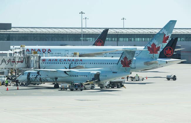 (200322) -- TORONTO, March 22, 2020 -- Passenger planes of Air Canada are seen at Pearson International Airport in Toronto, Canada, March 21, 2020. Air Canada is laying off more than 5,000 flight attendants as the country s largest airline cuts routes and parks planes due to the COVID-19 pandemic. The temporary layoffs will take effect by April. (Photo by Xinhua) CANADA-TORONTO-COVID-19-AIR CANADA-LAY OFF ZouxZheng 