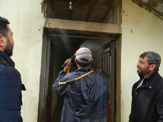 (200322) -- BEIRUT, March 22, 2020 (Xinhua) -- People disinfect a house belonging to a Syrian refugee family in southern Lebanon on March 21, 2020. Syrian refugee camps and houses in southern Lebanon were disinfected Saturday by local authorities. Lebanon s number of COVID-19 cases increased on Saturday to 206, the National News Agency reported, quoting the health ministry. (Photo by Taher Xinhua) LEBANON-BEIRUT-REFUGEE CAMPS-DISINFECTION 