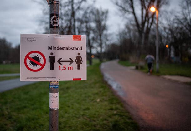 Themenfoto: Verbote wegen Coronavirus, Corona Virus, Covid-19 Mindestabstand 1,5m Schild im Dunkeln mit Jogger im Hintergrund, Themenfoto: Verbote wegen Coronavirus, Corona Virus, Covid-19, Copyright: xThomasxHahnx Eibner-Pressefotox EP_thn