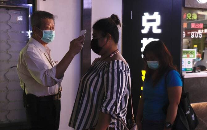 March 22, 2020, Hong Kong, CHINA: Foreign visitors receive thermo check by the security guard at the entrance of local shopping arcade.Mar-22,2020 Hong Kong.ZUMA Hong Kong CHINA - ZUMAl137 20200322_zap_l137_004 Copyright: xLiauxChung-renx