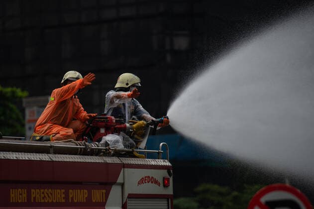 (200322) -- JAKARTA, March 22, 2020 -- Firefighters use a fire truck to spray disinfectant on the sidewalk along a main street in Jakarta, Indonesia, on March 22, 2020. The COVID-19 outbreak has claimed 38 lives in Indonesia, and 81 new cases were confirmed on Saturday, bringing the total to 450 in the country, the Indonesian government said on Saturday. ) INDONESIA-JAKARTA-COVID-19-CASES VerixSanovri 