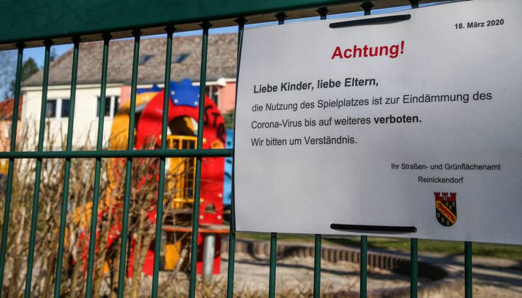 Coronavirus in Berlin Berlin, 22.03.2020, Sperrung Spielplatz. Schild zeigt Schriftzug: Achtung! Liebe Kinder, liebe Eltern, die Nutzung des Spielplatzes ist zur Eindaemmung des Corona-Virus bis auf weiteres verboten. Wir bitten um Verstaendnis. Ihr Strassen- und Gruenflaechenamt Reinickendorf. Hinter dem Zaun zeigen sich verlassene Spielgeraete. Berlin Berlin Deutschland Reinickendorf