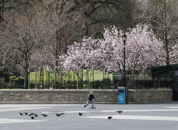 A boy rides a scooter in Union Square in New York City on Sunday, March 22, 2020. New York State Gov. Andrew Cuomo said the number of Coronavirus-related deaths in the state is now 114 and of the 15,168 positive cases, 9,045 have been in New York City.  NYP20200322103 JOHNxANGELILLO