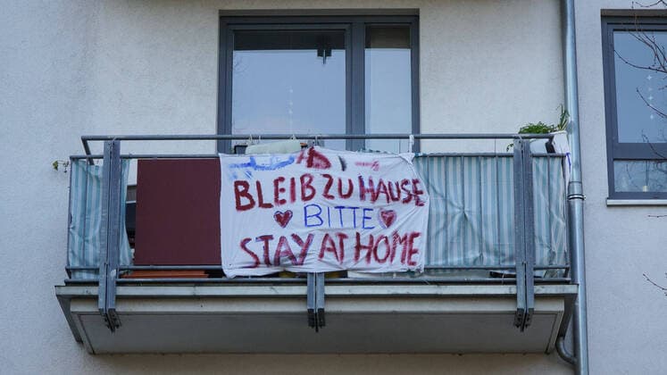 Zur Eindämmung des Coronavirus wurden Geschäftsschließungen, Einschränkungen und Kontaktsperren angeordnet und werden Ausgangssperren diskutiert, das Foto zeigt ein selbst gemaltes Banner, Transparent, Plakat an einem Wohnhaus, Aufschrift: Bleib zu hause bitte, Stay at home please, 22.03.2020, Bremen (Deutschland), News, Feature, Coronavirus Bremen