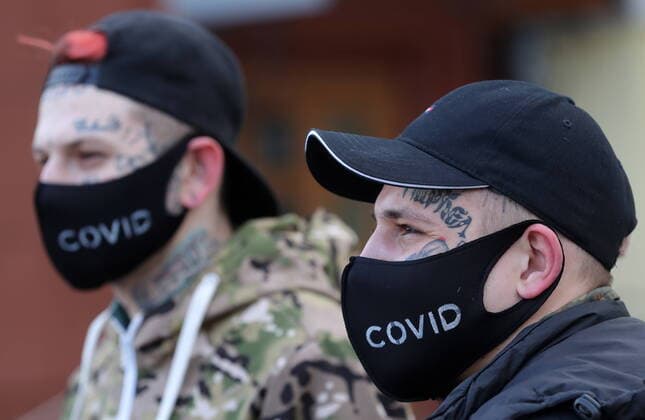 MOSCOW, RUSSIA - MARCH 22, 2020: Young men sport designer face masks outside the Bolshoi Theatre amid the ongoing COVID-19 pandemic. Sergei Karpukhin TASS  TS0D3119