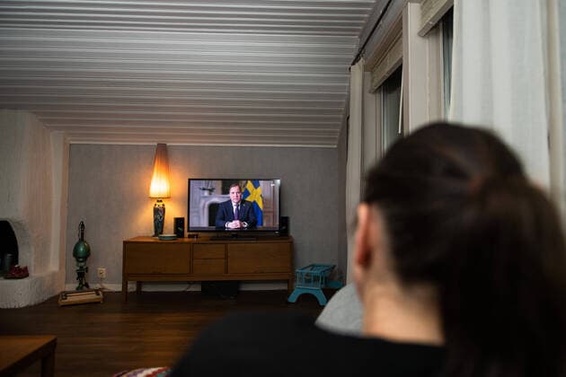 200322 En kvinna tittar pa ett tv-sänt tal till nationen av sveriges statsminister Stefan Löfven med anledning av coronaviruset covid-19 den 22 mars 2020 i Örby. Copyright: MATHIASxBERGELD 47089481st