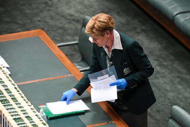 CORONAVIRUS LEGISLATION PARLIAMENT, An attendant prepares paper work ahead of parliamentary sitting under rules of social distancing in the House of Representatives at Parliament House in Canberra, Monday, March 23, 2020. ( NO ARCHIVING, EDITORIAL USE ONLY, NO USE IN BOOKS WITHOUT CONSENT CANBERRA ACT AUSTRALIA  Copyright: xLUKASxCOCHx 20200323001458840151