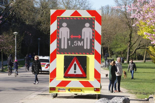 People walking pass a sign urging people to practice social distancing and keep 1.5 meters at the Vondelpark on March 22, 2020 in Amsterdam,Netherlands.The Dutch government ordered all Dutch schools, cafes, restaurants, coffeeshops, sex clubs and sport and fitness clubs to be closed as the government sought to prevent the further spread of coronavirus in the Netherlands. Amsterdam Netherlands Copyright: xPauloxAmorimx PAWP3J8U0813